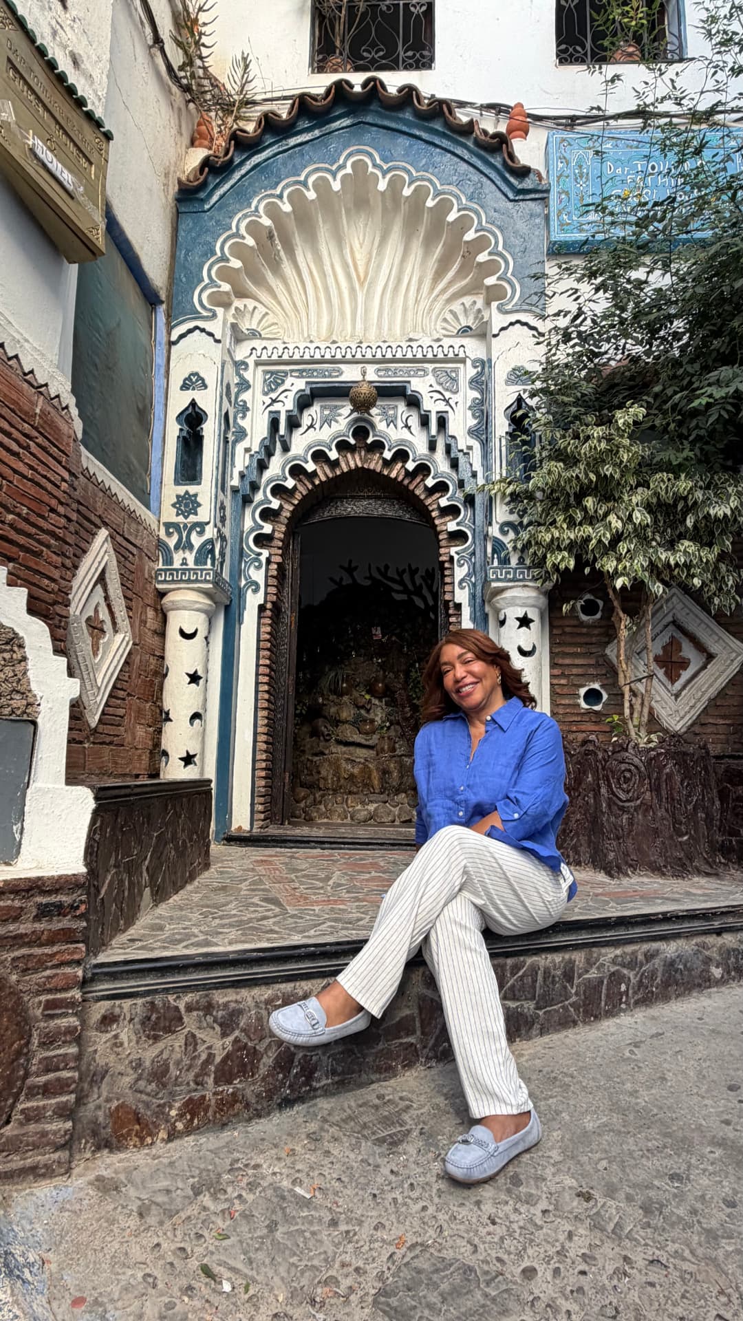 Clara Victoria con un look azul frente a una puerta tradicional de Chefchaouen